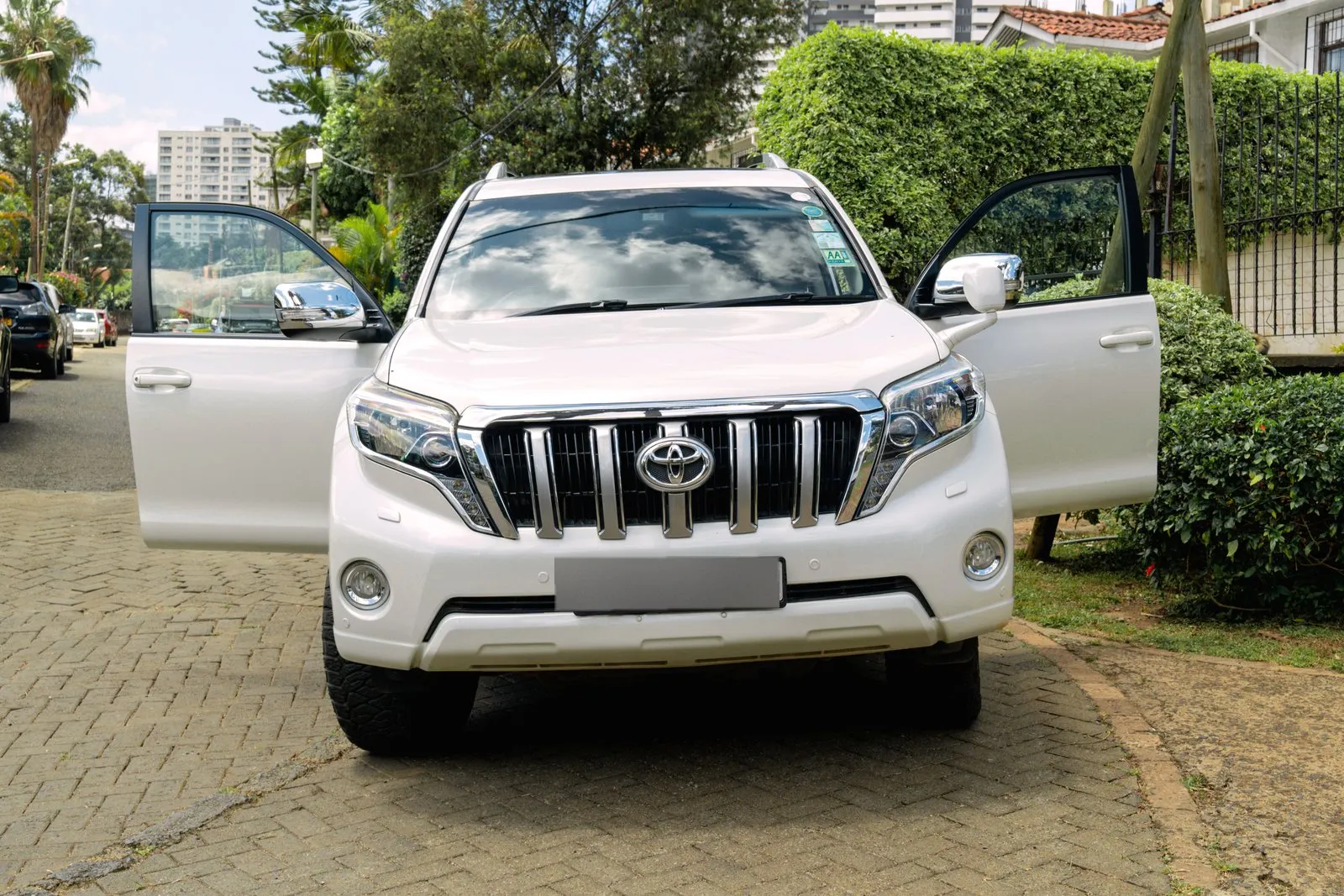 Prado with both front doors open on a driveway